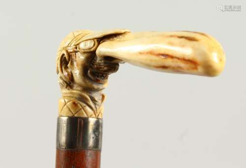 A WALKING STICK with carved ivory handle, a jockey with a long nose. 2ft 10ins long.