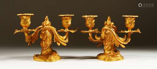 A PAIR OF SMALL ORMOLU TWIN BRANCH CANDELABRA in the Rococo style. 14cms high.