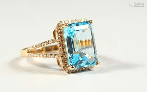 A 14k YELLOW GOLD AND DIAMOND RING set with an emerald cut blue topaz.