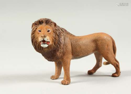 A PAINTED COLD CAST LION. 9cms long.