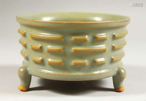 A SMALL CHINESE CELADON CIRCULAR BOWL with ribbed sides on three legs. 4.5ins diameter.