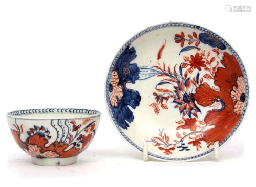 Unusual Lowestoft porcelain tea bowl and saucer with an Imari type tobacco leaf design in iron red
