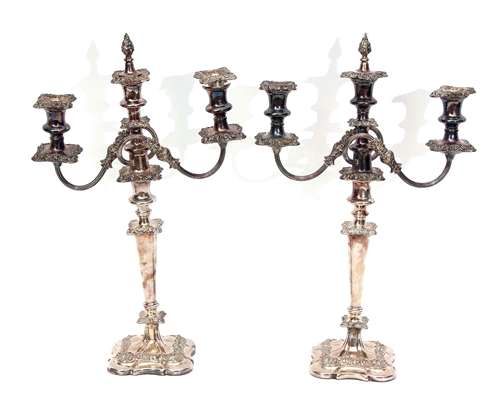 Two early 20th century silver on copper three-light candelabra, each with square section nozzles and