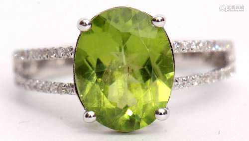 Modern peridot and diamond cluster ring set with an oval cut peridot, 3.48ct (est), raised between