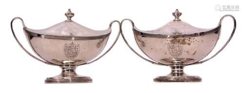 Two George III lidded tureens each of oval form with tapering strapwork handles and raised on