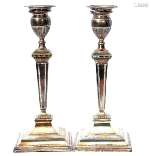 Two George III single light candlesticks, each with detachable nozzles with beaded rims to