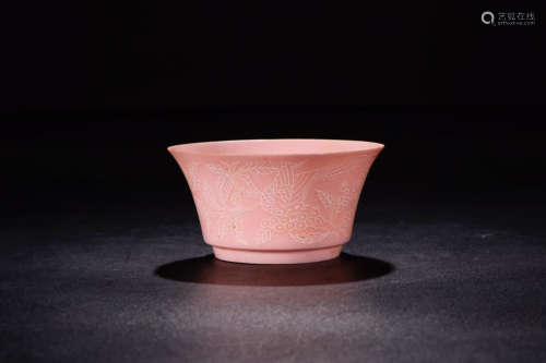 A RED GLAZED HORSE-HOOF CUP IN BLOSSOMS