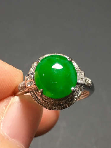 A GREEN JADEITE CARVED CIRCLE RING