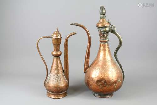 Two Islamic Copper Ewers; the ewers approx 30 and 40 cms respectively