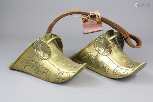 A Pair of South American Brass Stirrups; the stirrups with original leather strap