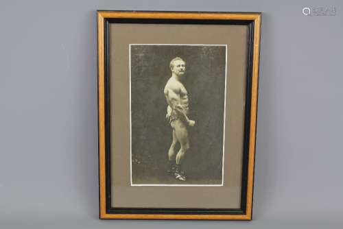 A Sepia Photo Print on Card of German Strongman Eugene Sandow, full-length pose with handlebar mustache and leopard-print briefs, as photographed by The Swiss Studio Melbourne, approx 12w x 19 h cms