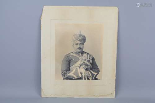 A Black and White Photograph of an Indian Officer, depicted seated in full dress uniform, approx 24 w x 29 h cms, photographed by Johnston & Hoffmann Calcutta & Simla