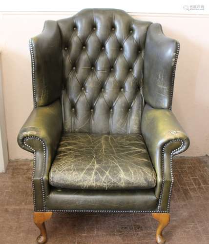 A Green Leather Wing-back Arm Chair, in the Chesterfield style