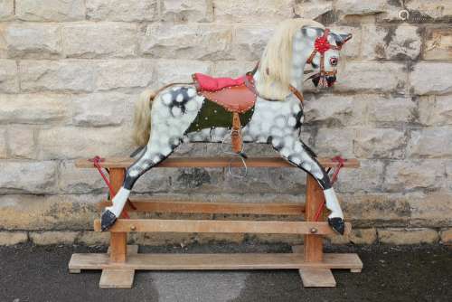 An English-Made Vintage Rocking Horse, dappled grey with original saddle and iron stirrups (af), good quantity of mane and tail remain, good restoration project