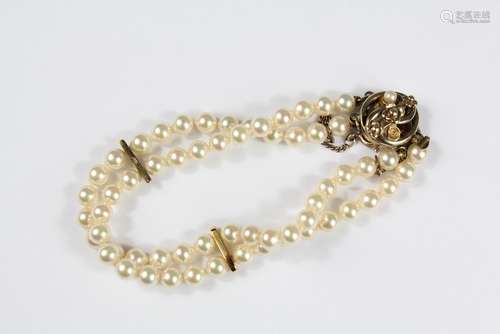 A Lady's Pearl Bracelet, strung with two rows of pearls held by a silver-gilt clasp and safety chain