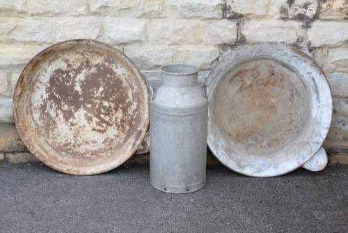Dairy Farm Equipment; this lot includes two large round milk pans with pouring lips, approx 35 cms dia, together with a large milk urn approx 72 cms h