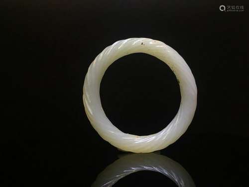 A CARVED WHITE JADE BANGLE.