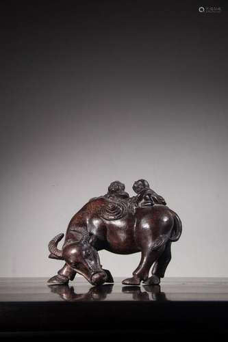 A CARVED AGALLOCJ WOOD BUFFALO AND BOYS. ANTIQUE