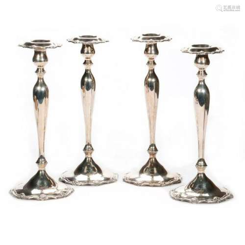 Four sterling candlesticks.