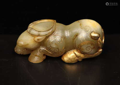A GILT HETIAN JADE CARVED COW ORNAMENT