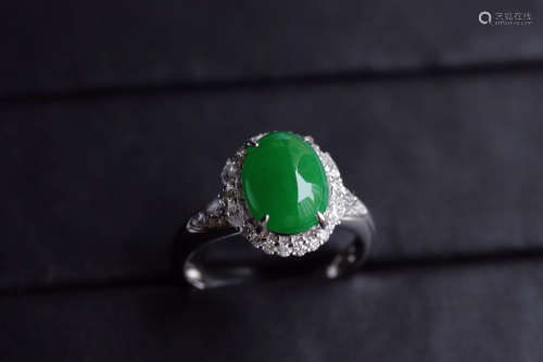A ZHENGYANG GREEN EGG-SHAPED JADEITE RING SURROUNDED WITH DIAMONDS