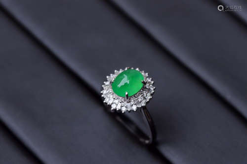 A ZHENGYANG GREEN EGG-SHAPED JADEITE RING SURROUNDED WITH DIAMONDS