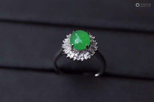 A ZHENGYANG GREEN EGG-SHAPED JADEITE RING SURROUNDED WITH DIAMONDS