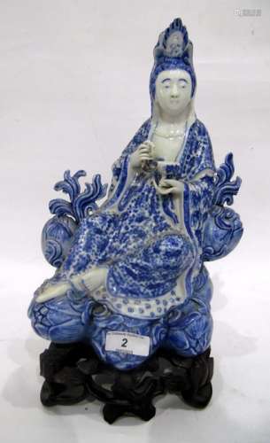 Chinese porcelain blue and white figure of a guanyin on a pierced wooden lotus leaf base,