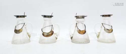 Four similar miniature glass jugs with silver rims and lids, each bearing silver bottle labels marke