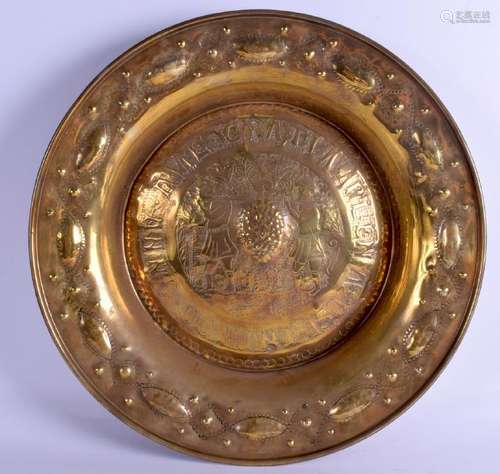 A 19TH CENTURY BRASS ALMS DISH decorated with figures