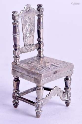 A SOLID SILVER MINIATURE CHAIR, decorated in relief