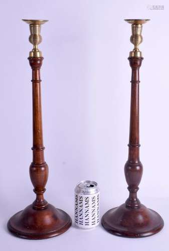 A LARGE PAIR OF MAHOGANY AND BRASS CANDLE STICKS. 51 cm