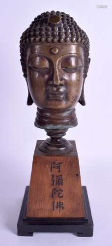 A 19TH CENTURY CHINESE BRONZE BUDDHA HEAD upon a wooden