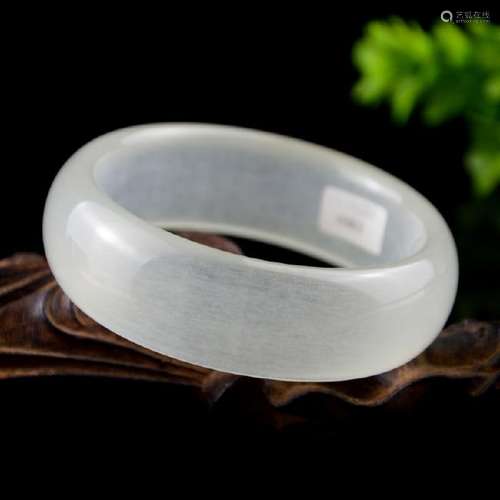 A NATURAL ICE JADE BANGLE.