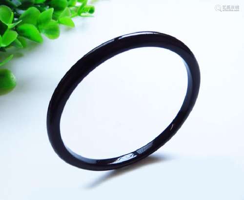 A NATURAL BLACK AGATE BANGLE.