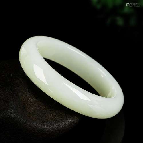 A NATURAL WHITE JADE BANGLE.