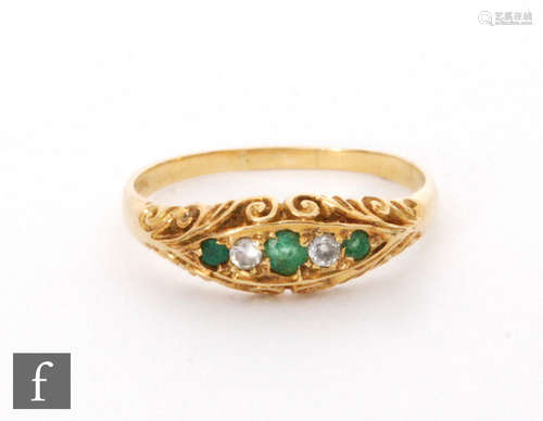 An 18ct emerald and diamond five stone boat shaped ring, alternating stones to scroll shoulders,