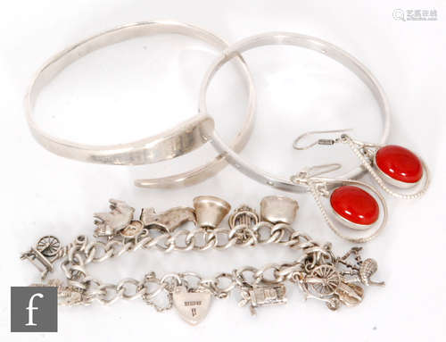 Five items of jewellery to include a silver charm bracelet, a torque and a hinged bangle etc. (5)