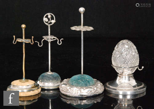 Three early 20th Century silver plated circular hat pin stands, with a similar ring tree with