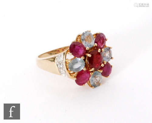 A 9ct hallmarked blue topaz and ruby cluster ring, claw set stones to diamond set shoulders, ring