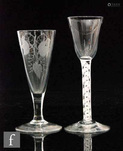 An 18th Century drinking glass with a round funnel bowl above a double series opaque twist stem