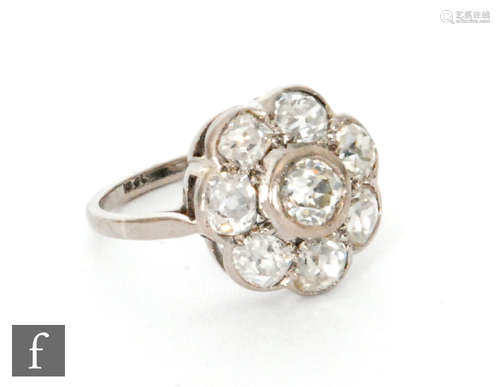 An early 20th Century 18ct white gold diamond daisy cluster ring, central collar set stone within