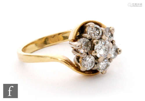 An 18ct hallmarked diamond cluster ring, seven claw set brilliant cut stones to tapering wrap around