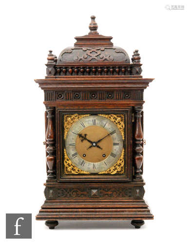 A late 19th to early 20th Century oak cased bracket clock, with turned finials and columns and blind