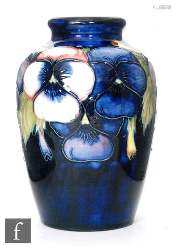 A 1930s William Moorcroft Pansy baluster vase decorated with flower heads and hanging buds against a