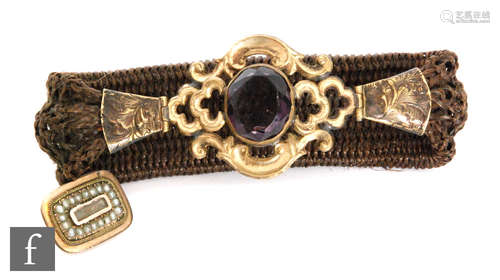 A 19th Century plaited hair expanding bracelet with gilt mounted and central collar set purple