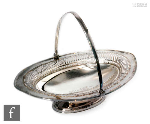 A hallmarked silver oval pedestal bread basket of plain form with pierced border below swing handle,