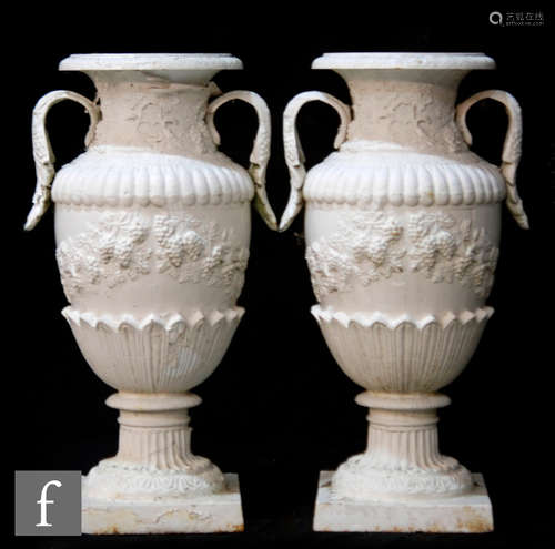 A pair of white painted cast iron twin handled terrace vases, each with gadrooned borders, over