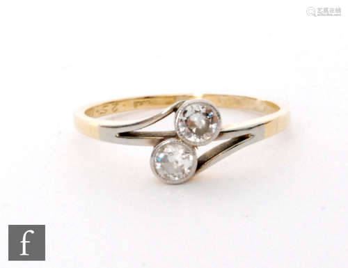 An early 20th Century 18ct diamond two stone cross over ring, millgrain set transitional cut