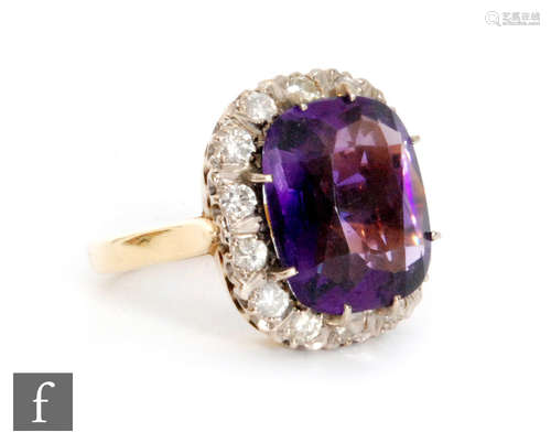 An 18ct amethyst and diamond cluster ring, central cushion cut amethyst, length 15mm, within a